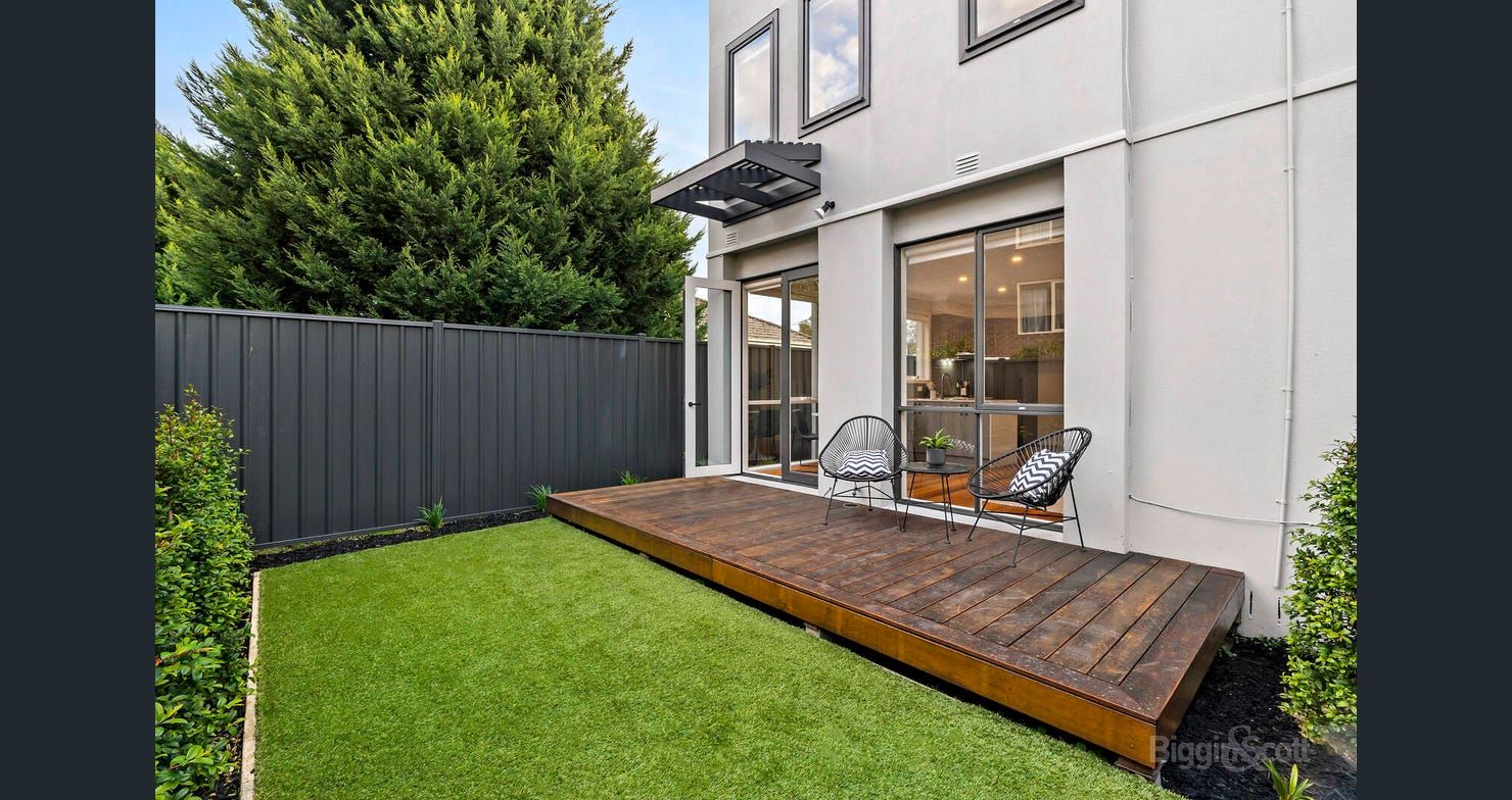 Rear courtyard with deck and lawn