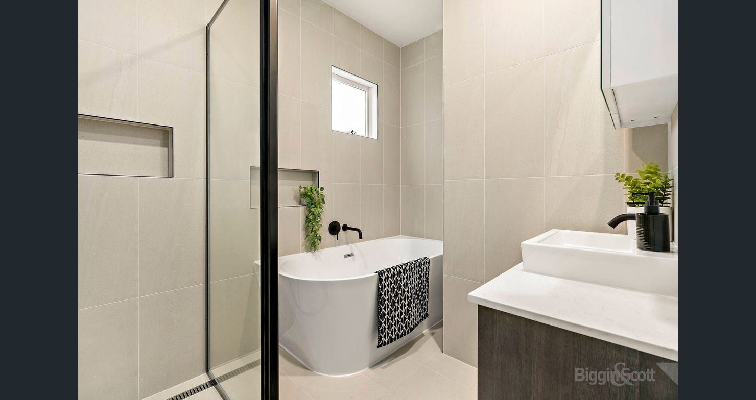 Bathroom with freestanding bath and full-height tiling