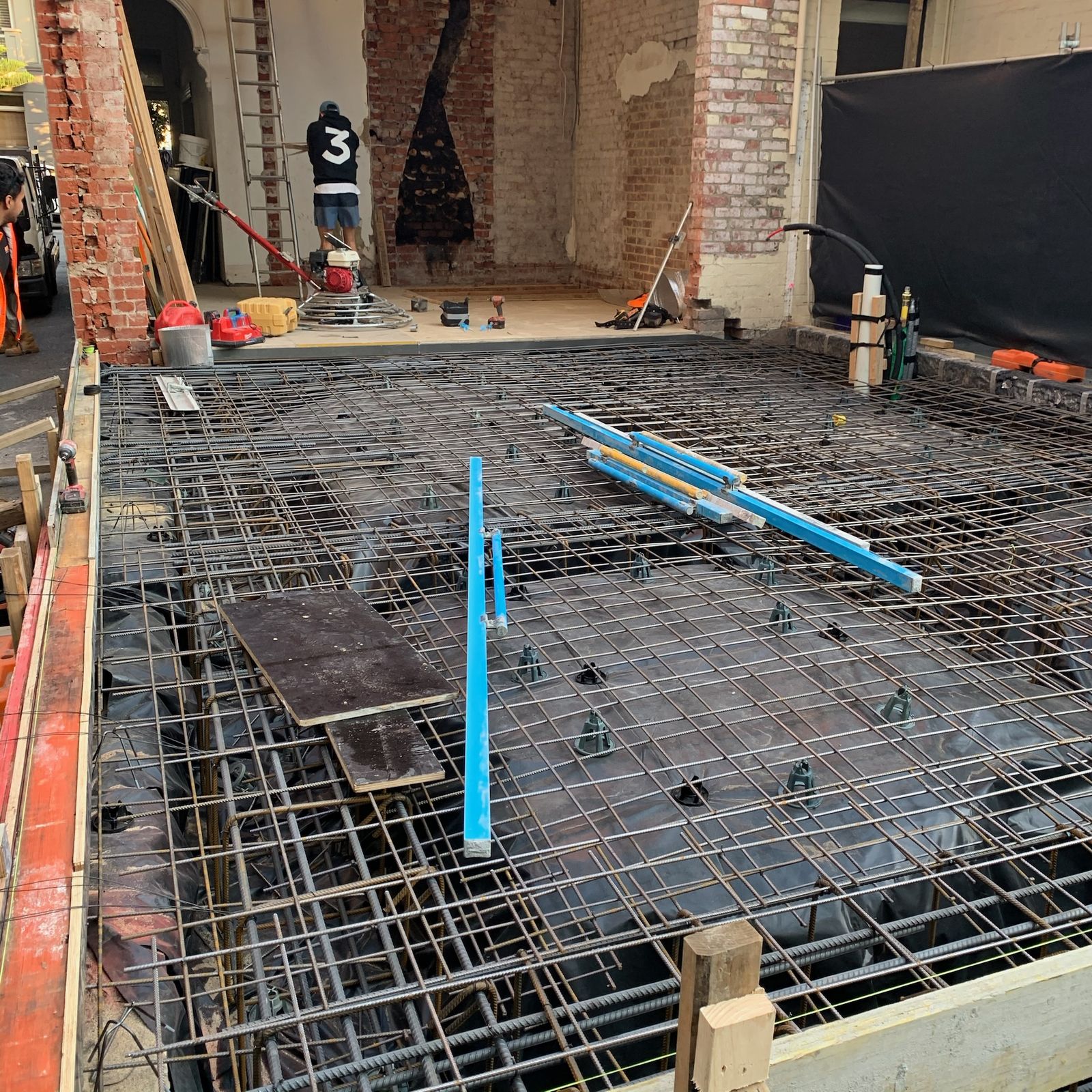 Reinforced slab prepared for pouring, with heritage brick walls behind
