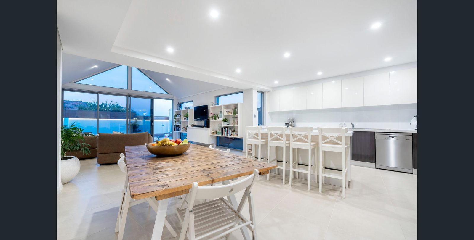 Open-plan kitchen and dining under a vaulted glass roofline
